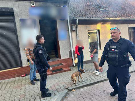 Funkcjonariusze policji przy zadymionym budynku
