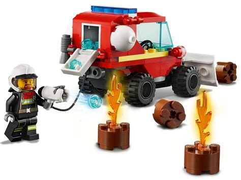 Minifigurka strażaka z megafonem i hełmem, obok mały wóz strażacki LEGO