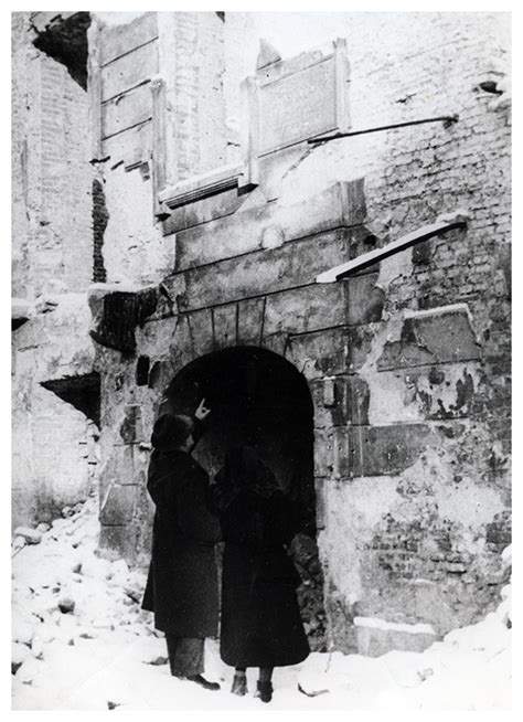 zdjęcie młodej rodziny stojącej przed zniszczonym przez pożar domem