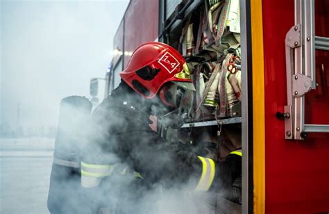Zdjęcie z miejsca akcji przedstawiające pracę strażaków przy gaszeniu zabudowań