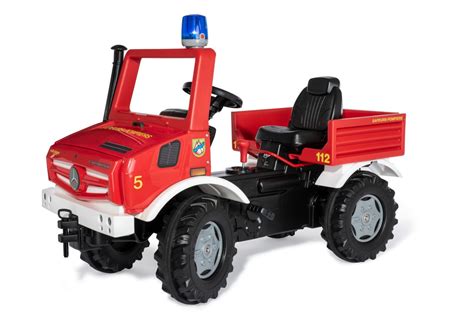 Zbliżenie na detale wozu strażackiego Rolly Toys Unimog Mercedes: panel sterowania, hamulec ręczny, regulowany fotel.