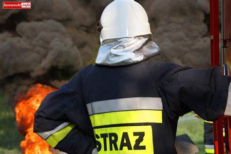 zdjęcie przedstawiające pracę strażaków przy ciężkim wozie gaśniczym w warunkach polowych