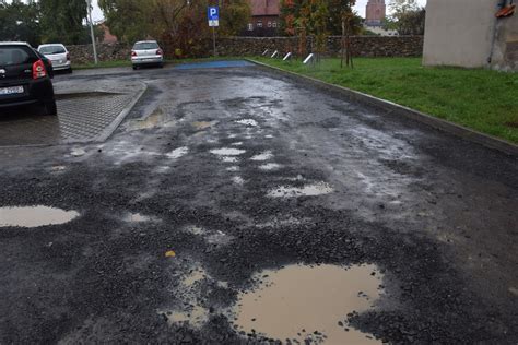 Zdjęcie przedstawiające spalone samochody na parkingu przy ul. Siennej w Pabianicach, z widocznymi śladami pożaru.