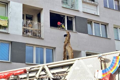 strażacy wynoszący nadpalone przedmioty z mieszkania