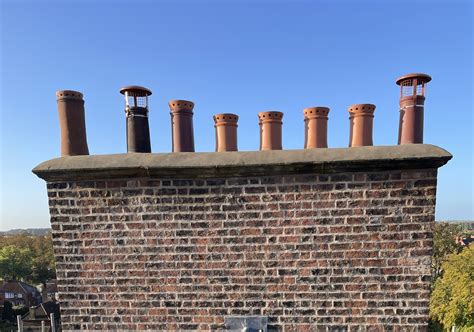 Thematic photo of a chimney cowl on a roof against a changeable sky