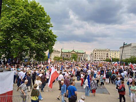 Tłumy ludzi bawiących się na plenerowej imprezie sylwestrowej na placu w mieście, fajerwerki na niebie