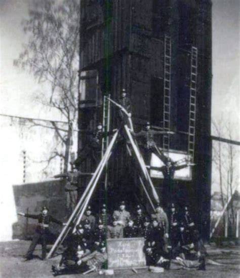 Załoga lubańskiej Straży Pożarnej w trakcie zawodów pożarniczych na tle wieży pożarniczej przy ul. Podwale (rok 1947 lub 1948)