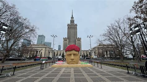 Zdjęcie zniczy i kwiatów złożonych pod Pałacem Kultury