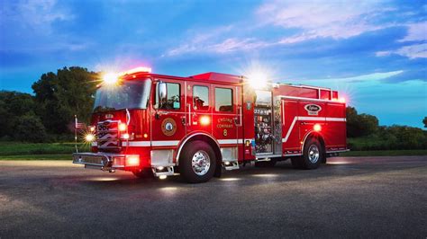 Thematic photo of a modern fire truck with firefighters in front of it