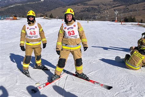 Strażacy OSP na nartach i snowboardzie w pełnym umundurowaniu