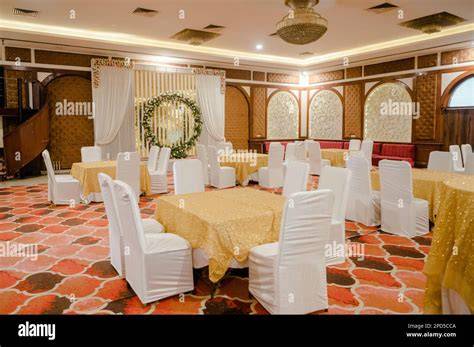 The interior of a versatile event hall, ready for a celebration, with tables and chairs set up.