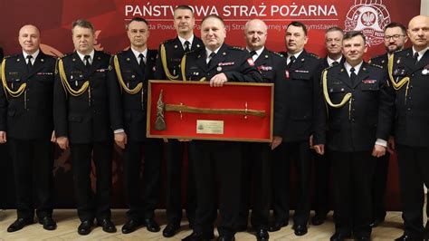Zdjęcie przedstawiające uroczystą zbiórkę strażaków podczas ceremonii pożegnania dowódcy zmiany.