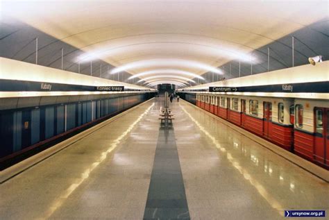 Stacja metra Kabaty nocą, z sylwetkami osób oczekujących na pociąg
