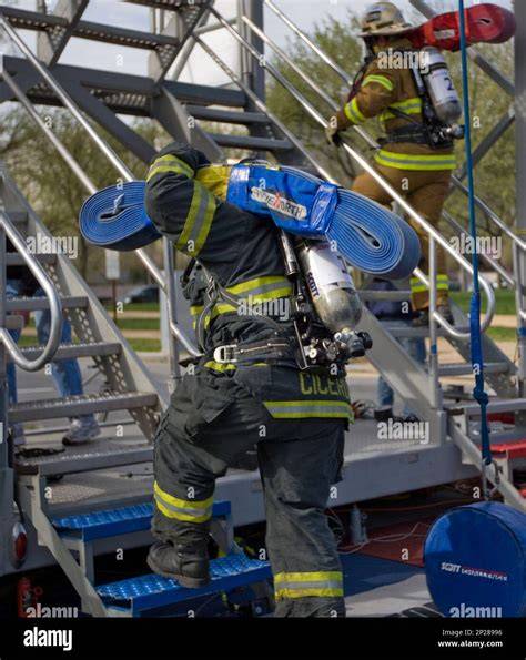 Thematic photo of a firefighter in full gear competing in a FireFit event, possibly climbing a tower or dragging a dummy
