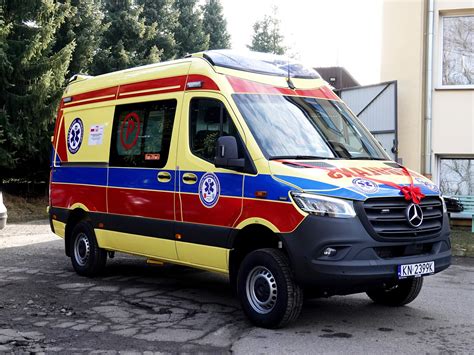 Wóz strażacki i karetka pogotowia przed budynkiem mieszkalnym nocą