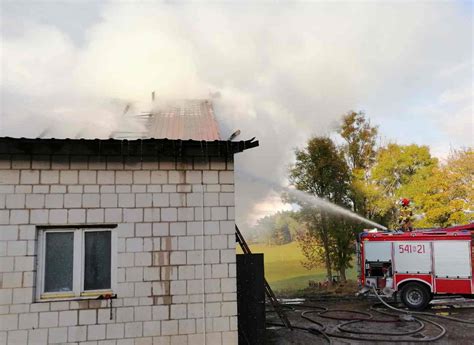 Pożar budynku inwentarskiego z widoczną akcją gaśniczą i dymem