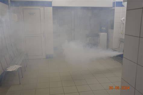 Zadymione pomieszczenie, w tle spalona pralka, strażacy w aparatach ODO