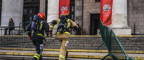 Zdjęcie strażaków w sprzęcie pożarniczym podczas biegu po schodach Sky Tower Run
