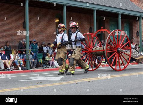 Photo of a large gathering or parade of firefighters with historical and modern equipment