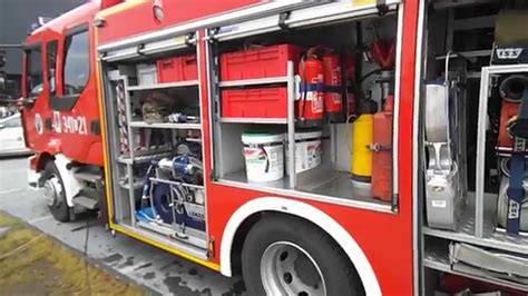 Zdjęcie przedstawiające różnorodny sprzęt strażacki Rosenbauer na tle wozu strażackiego