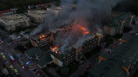 Widok z zewnątrz na płonący dach dziesięciopiętrowego bloku mieszkalnego