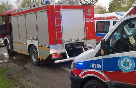 Zniszczone samochody po wypadku drogowym, na miejscu służby ratunkowe (straż pożarna, karetka, policja)