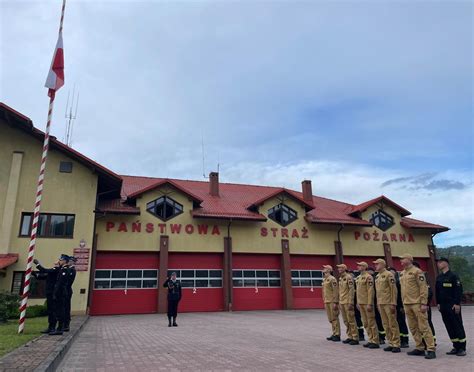 nowoczesna siedziba Państwowej Straży Pożarnej w Suchej Beskidzkiej z placem manewrowym i zaparkowanymi wozami bojowymi