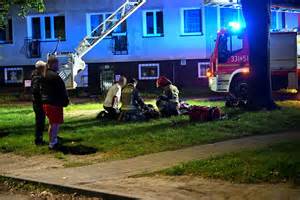 Strażacy gaszący pożar w budynku mieszkalnym, akcja ratunkowa i ewakuacja