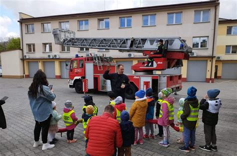 dzieci z uśmiechem witające strażaka w przedszkolu