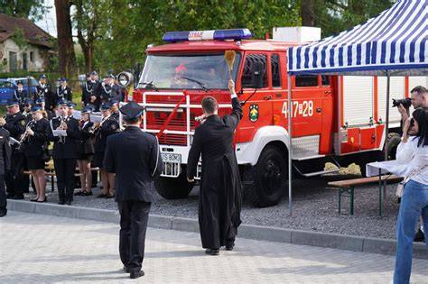 Uroczysta zbiórka strażaków z pocztami sztandarowymi przed nową remizą OSP
