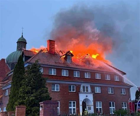 płonący budynek mieszkalny, strażacy operują wężami