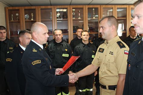 Zdjęcie odznaczonych strażaków z medalami i dyplomami