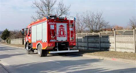 zdjęcie wozu strażackiego w akcji gaszenia pożaru