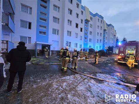 Miejsce pożaru w bloku mieszkalnym, akcja straży pożarnej