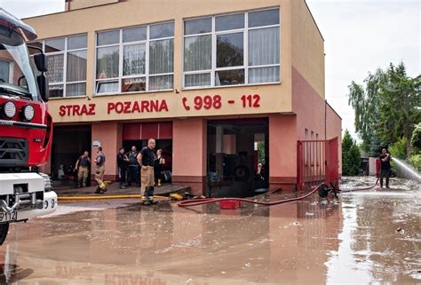 Zniszczona remiza OSP po powodzi, strażacy sprzątający zalany teren