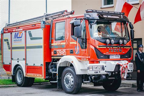 Wóz strażacki i strażacy gaszący pożar samochodu