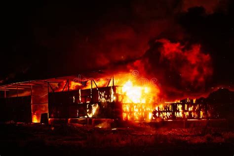 Thematic photo of a burning industrial building at night, with firefighters working