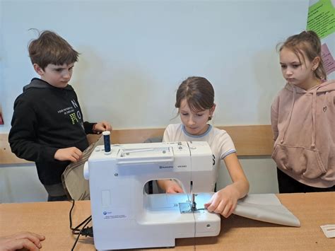 Zdjęcie przedstawiające Melek i Elif w skromnej pracowni krawieckiej, Melek szyjąca, Elif obok