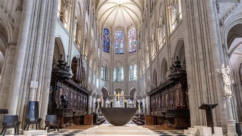 Wnętrze katedry Notre-Dame po pożarze, z widocznymi organami i częściowo zniszczonym sklepieniem.