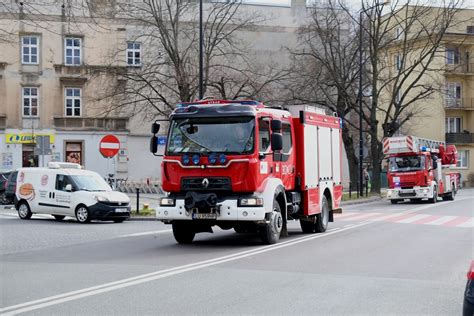 Zdjęcie strażaków w trakcie dogaszania pożaru, z widocznym ciężkim sprzętem, takim jak koparki