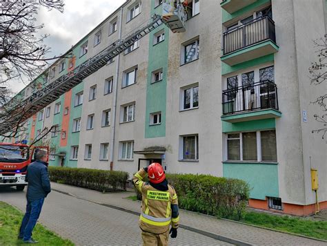 Strażacy wchodzący przez okno do mieszkania w celu ratowania osoby nieprzytomnej