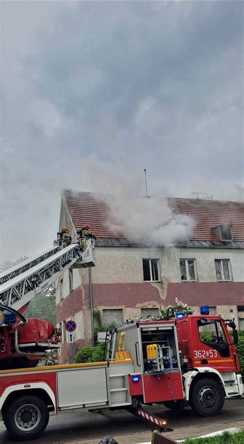 Akcja gaśnicza straży pożarnej przy płonącym budynku mieszkalnym