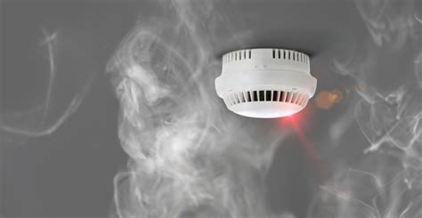 Ilustracja przedstawiająca czujnik dymu zamontowany na suficie.