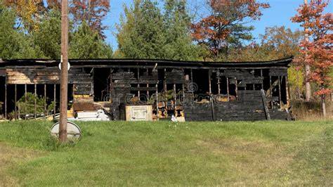 Photo of a large rural building damaged by fire, possibly a barn or farm structure