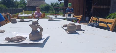 Dzieci uczestniczące w warsztatach garncarstwa, lepiące z gliny.