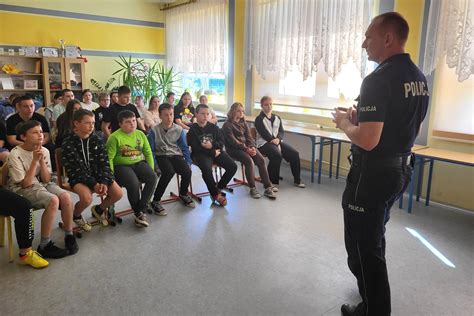 Policjant rozmawiający z grupą dzieci w klasie szkolnej na temat bezpieczeństwa