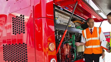 Specialist inspecting a burnt engine compartment of a bus