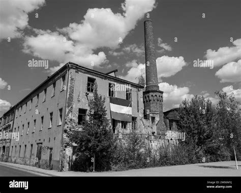 Thematic photo of an old, abandoned factory in Łódź with smoke in the background