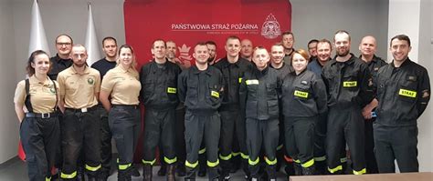 Zdjęcie grupowe strażaków z Andrzejem Nowakiem na tle jednostki JRG 7