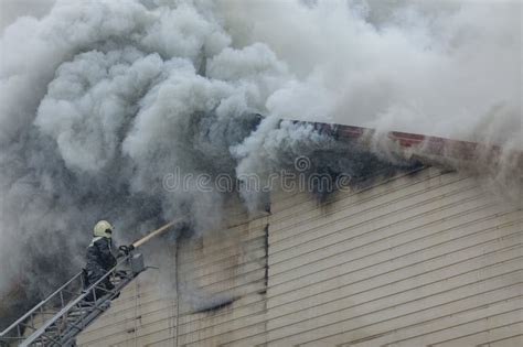 Thematic photo of a burning barn with heavy smoke and emergency vehicles
